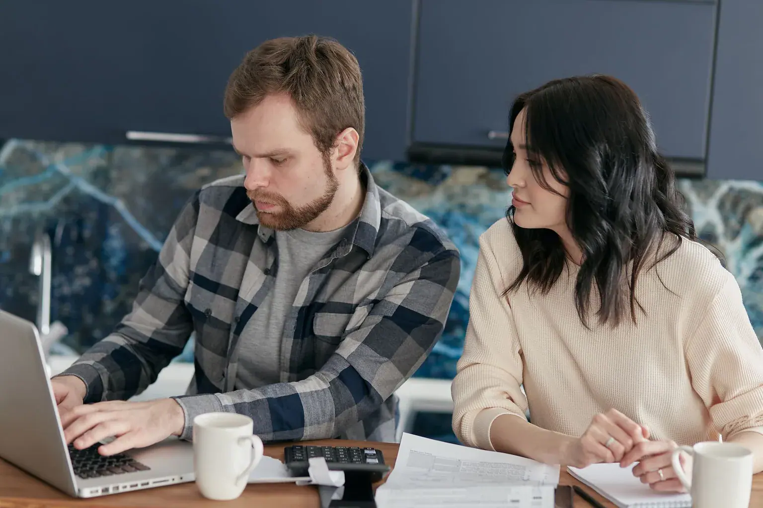 A couple reviewing paperwork together at a laptop